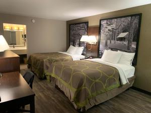 a hotel room with two beds and a desk at Super 8 by Wyndham Cookeville, TN in Cookeville +19 photos