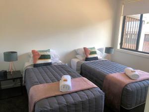 a bedroom with two beds with towels on them at The Grounds at Callaghan in Jesmond