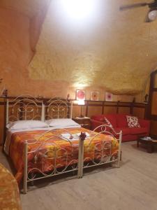 ナポリにあるLittle Houseのベッドルーム1室(ベッド1台、洞窟内のソファ付)