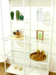 a white book shelf with glasses and a plate at Bright Renovated Room Close to Everything in Jerusalem
