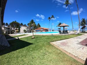 a resort with a swimming pool and the ocean at Chalés Village Gales in Maragogi