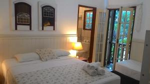 um quarto com uma cama com toalhas em Recanto da Praia em Paraty