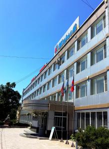 a hotel building with flags in front of it at Hotel Turist in Yuzhno-Sakhalinsk