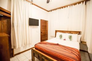 a bedroom with a bed and a television in it at Falling Leaves Lodge in San Ignacio