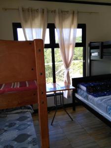 a bedroom with two bunk beds and a window at Banga-an BnB and Coffee House in Sagada