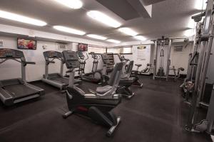 a gym with treadmills and ellipticals in a room at Waikiki Monarch Hotel in Honolulu