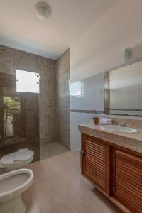a bathroom with a toilet and a sink and a shower at Village Muta in Porto Seguro