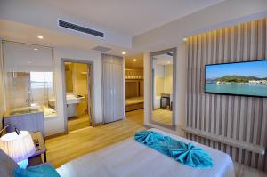 - une chambre avec une télévision murale et un lit dans l'établissement The MCR Luxury Nha Trang, à Nha Trang