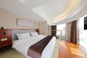 Postel nebo postele na pokoji v ubytování Shanghai Menglong Hotel Management