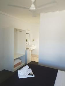 a white room with a bed and a bathroom at Pit Pony Hotel in Collinsville