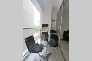 a glass table and two chairs in a room at Departamento 1 habitación zona exclusiva in Asuncion
