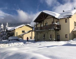 una persona parada en la nieve frente a un edificio en Departamento Piedra del Condor en San Carlos de Bariloche