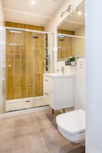 a white bathroom with a shower and a toilet at Tribeca City Center Apartments in Krakow