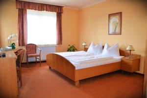 a bedroom with a large bed and a window at Hotel Weldi in Győr