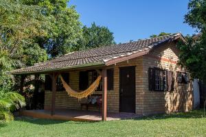 a small brick house with a porch and a window at Cabanas Areias in Praia do Rosa
