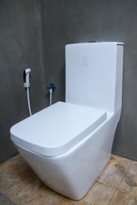 a white toilet in the corner of a bathroom at YalaWay Nature Villa in Tissamaharama