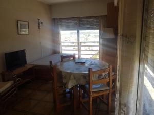 mesa y sillas en una habitación con ventana en Sur Xii Monoambiente en Miramar