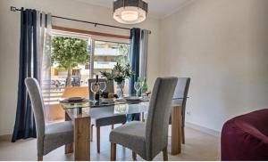 a dining room with a table and chairs and a window at Apartamento Amarelo in Conceição