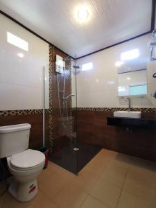 a bathroom with a toilet and a shower and a sink at Lanta Sunny House in Ko Lanta