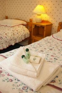a bedroom with two towels and two bottles on a bed at Laundry Cottage in Lanark