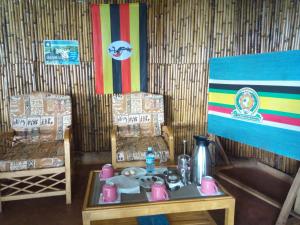 una stanza con tavolo e due sedie e bandiera di Sipi Coffee Lodge a Kapchorwa Altre 37 foto