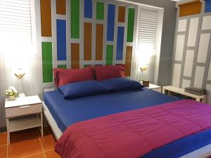 a bedroom with a large bed with a colorful headboard at Baan Baimai Boutique Room in Phra Nakhon Si Ayutthaya