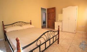 a bedroom with a large bed and a kitchen at Fitzy Haven in Gros Islet