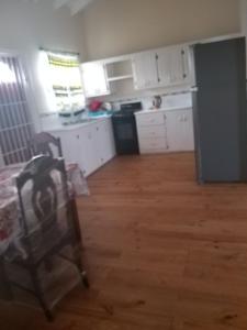 kuchnia z białymi szafkami, stołem i krzesłem w obiekcie Fitzy Haven w mieście Gros Islet