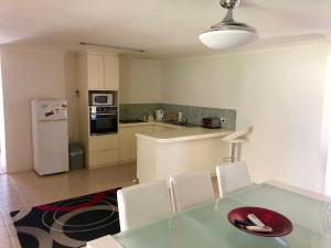 a kitchen with a table and chairs and a refrigerator at Relaxed Ocean View in Mandurah
