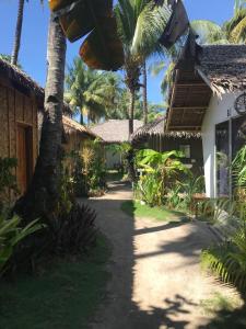 a pathway leading to a house with palm trees at Lukay Resort Siargao in General Luna