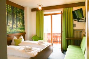 a hotel room with two beds and a balcony at Guesthouse Pension Grafenstein in Merano