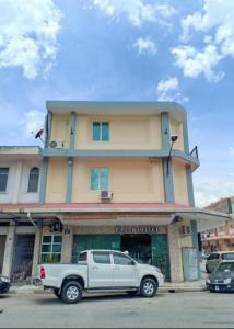 a white truck parked in front of a building at Fajar Hotel in Lahad Datu