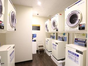 a laundry room with washing machines and a chair at APA Hotel & Resort Yokohama Bay Tower in Yokohama