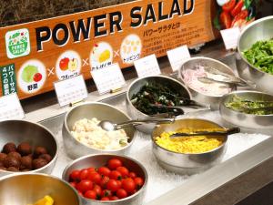 a buffet filled with bowls of food on a counter at APA Hotel & Resort Yokohama Bay Tower in Yokohama