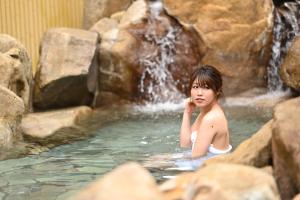 a young girl in a hot tub in a waterfall at Grampus Sea in Shirahama