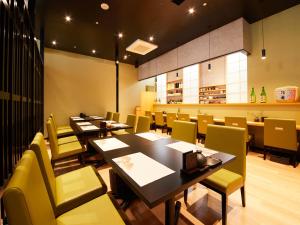 a dining room with tables and yellow chairs at APA Hotel & Resort Yokohama Bay Tower in Yokohama