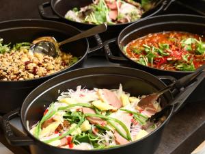 a group of four pans filled with different types of food at APA Hotel & Resort Yokohama Bay Tower in Yokohama