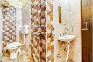 a bathroom with a toilet and a sink at FabHotel Gazal Residency Mahanagar in Lucknow +15 photos