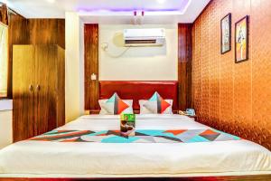 ein Schlafzimmer mit einem Bett in einem Zimmer in der Unterkunft FabHotel Gazal Residency Mahanagar in Lucknow