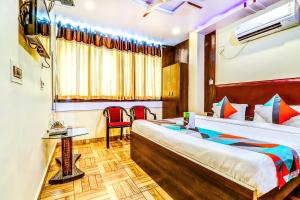 a hotel room with a bed and a table and chairs at FabHotel Gazal Residency Mahanagar in Lucknow
