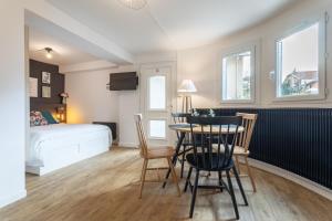 a room with a table and chairs and a bed at Le Cocon Parilly in Bron