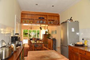 a kitchen with a stainless steel refrigerator and a table at On Pinewood Guest House in Cape Town