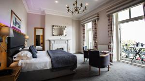 a bedroom with a bed and a table and chairs at Crown Spa Hotel Scarborough by Compass Hospitality in Scarborough