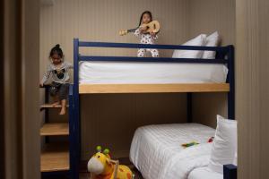 two children sitting on top of bunk beds at Eleven Bangkok Sukhumvit 11 by Kingston Hotels in Bangkok