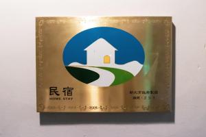 淡水民宿-台北Yes Hotel في تامسوي: علامة لإقامة المنزل على الحائط