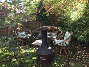 a garden with two chairs and a black vase at Un Autre Monde in Saint-Claude