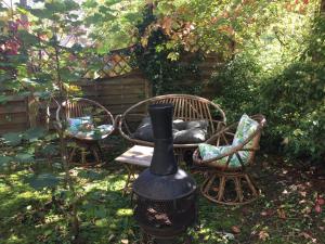 サン・クロードにあるUn Autre Mondeの椅子2脚と黒壺のある庭園