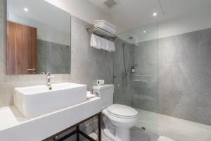 a bathroom with a toilet and a sink and a shower at True Siam Phayathai Hotel in Bangkok