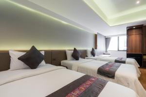 a hotel room with two beds and two lamps at True Siam Phayathai Hotel - SHA Extra Plus Certified in Bangkok