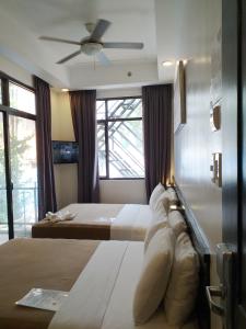 a bedroom with two beds and a ceiling fan at One Crescent Place Hotel in Boracay